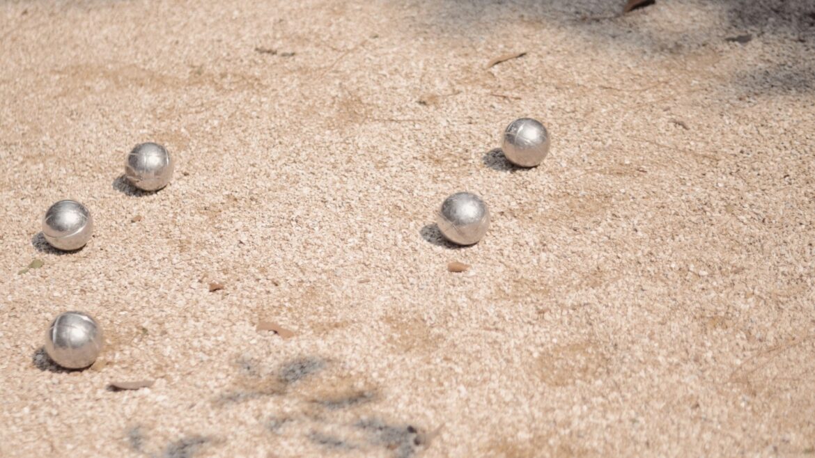 a group of balls sitting on top of a sandy ground