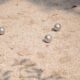 a group of balls sitting on top of a sandy ground